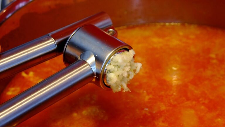 Garlic press over a soup pot